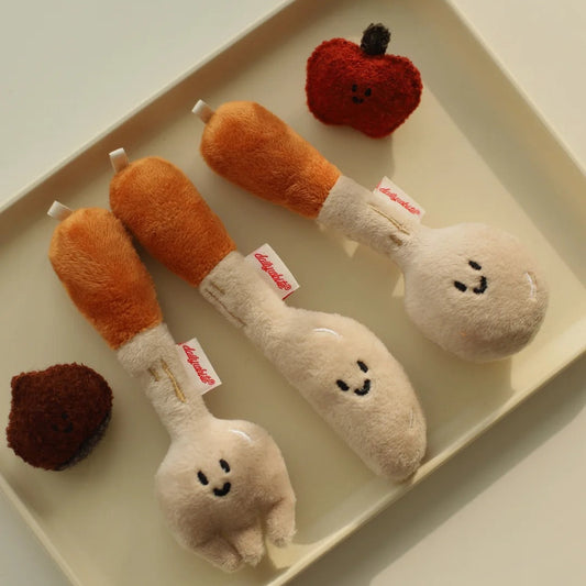 Set of plush toys resembling chicken drumsticks and wings on a tray.