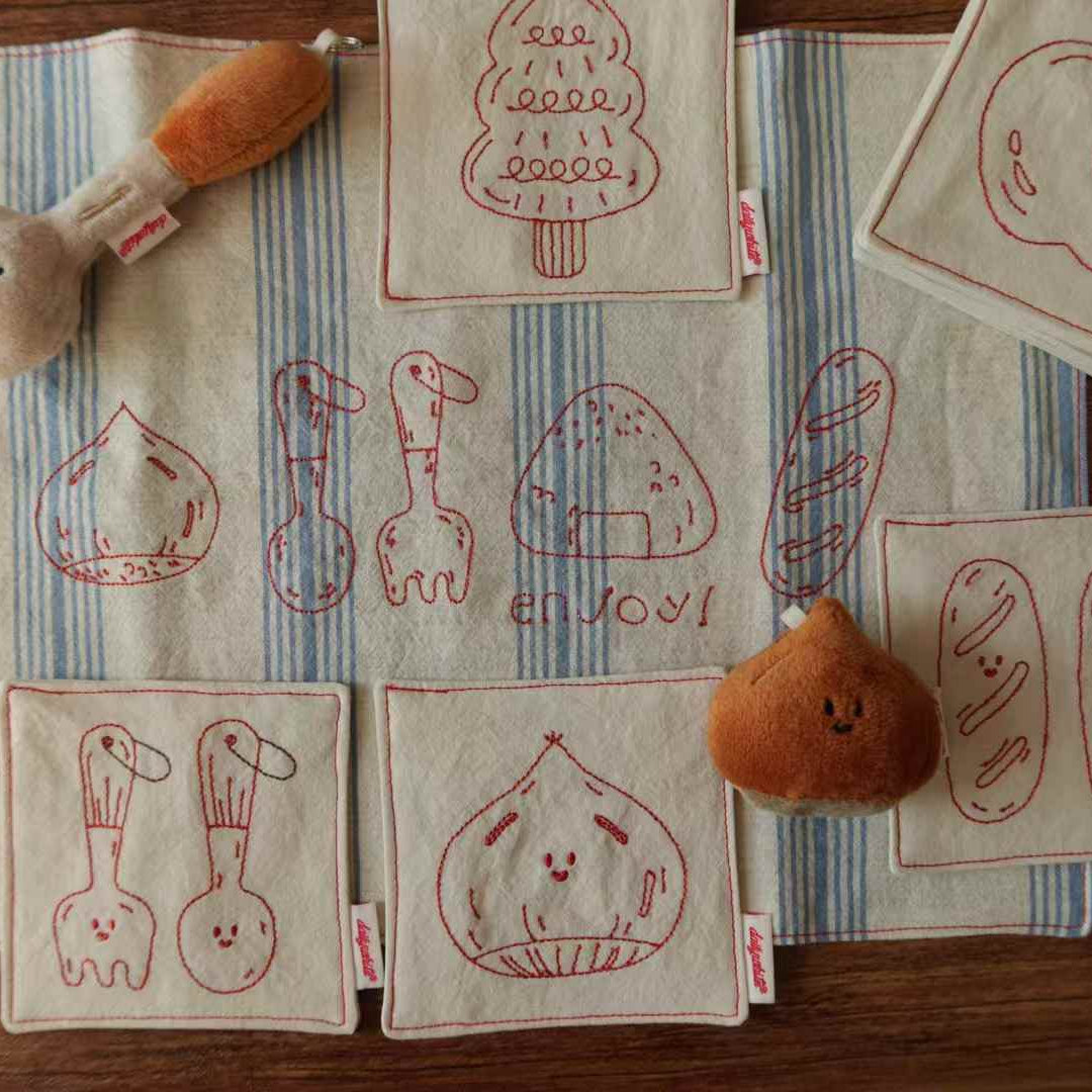 Fabric toys with embroidered designs on a striped fabric background