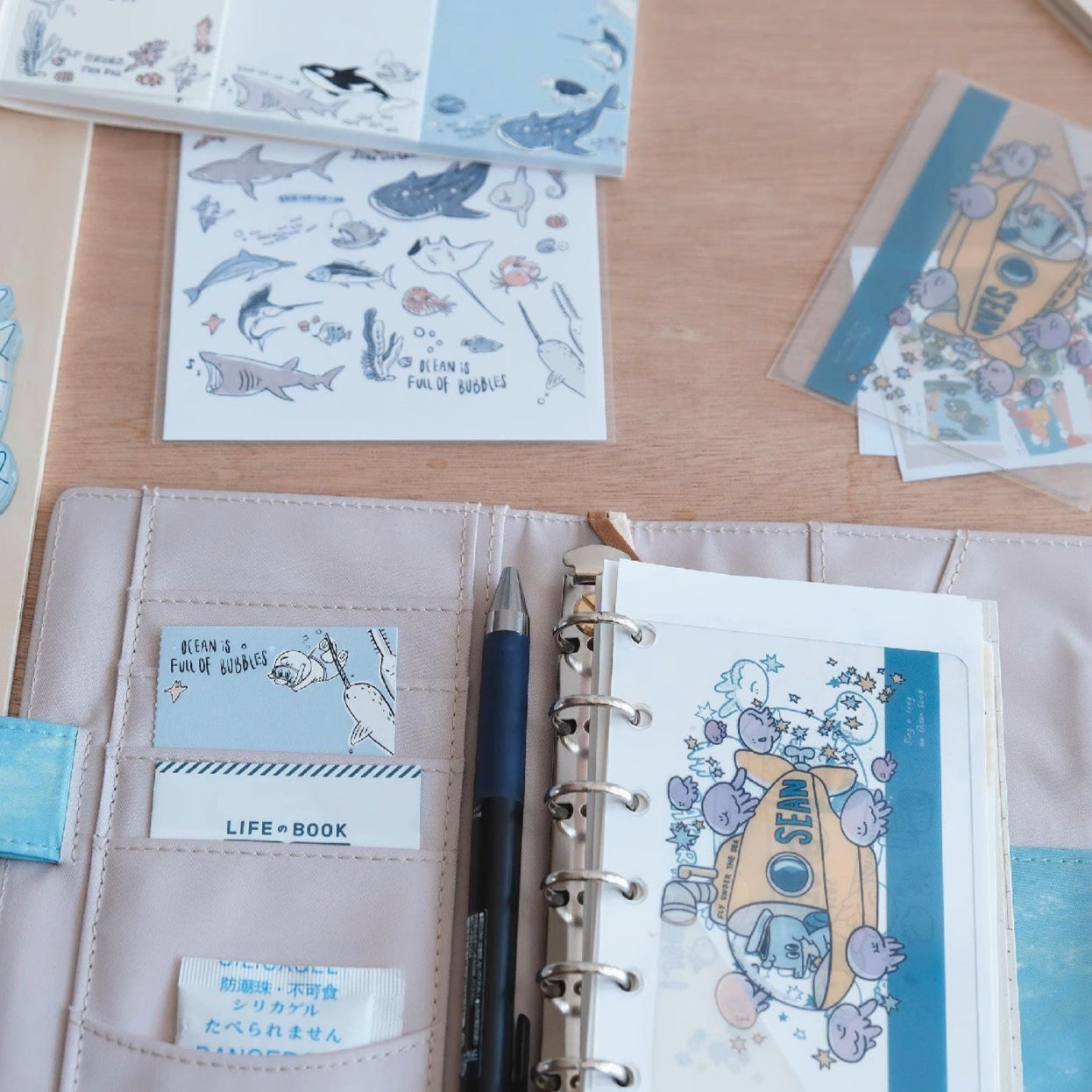 Notebook with stationery items on a wooden surface