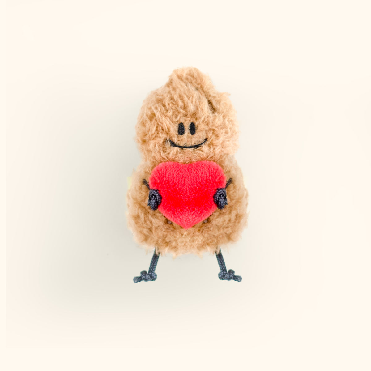 Plush toy with a red heart and smiling face on a white background