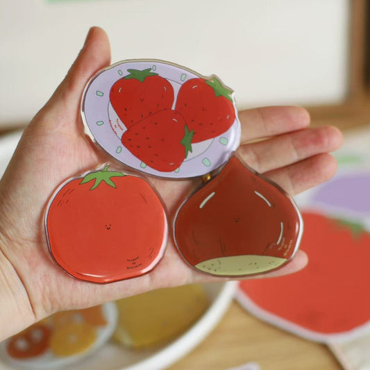 Hand holding strawberry-shaped magnet