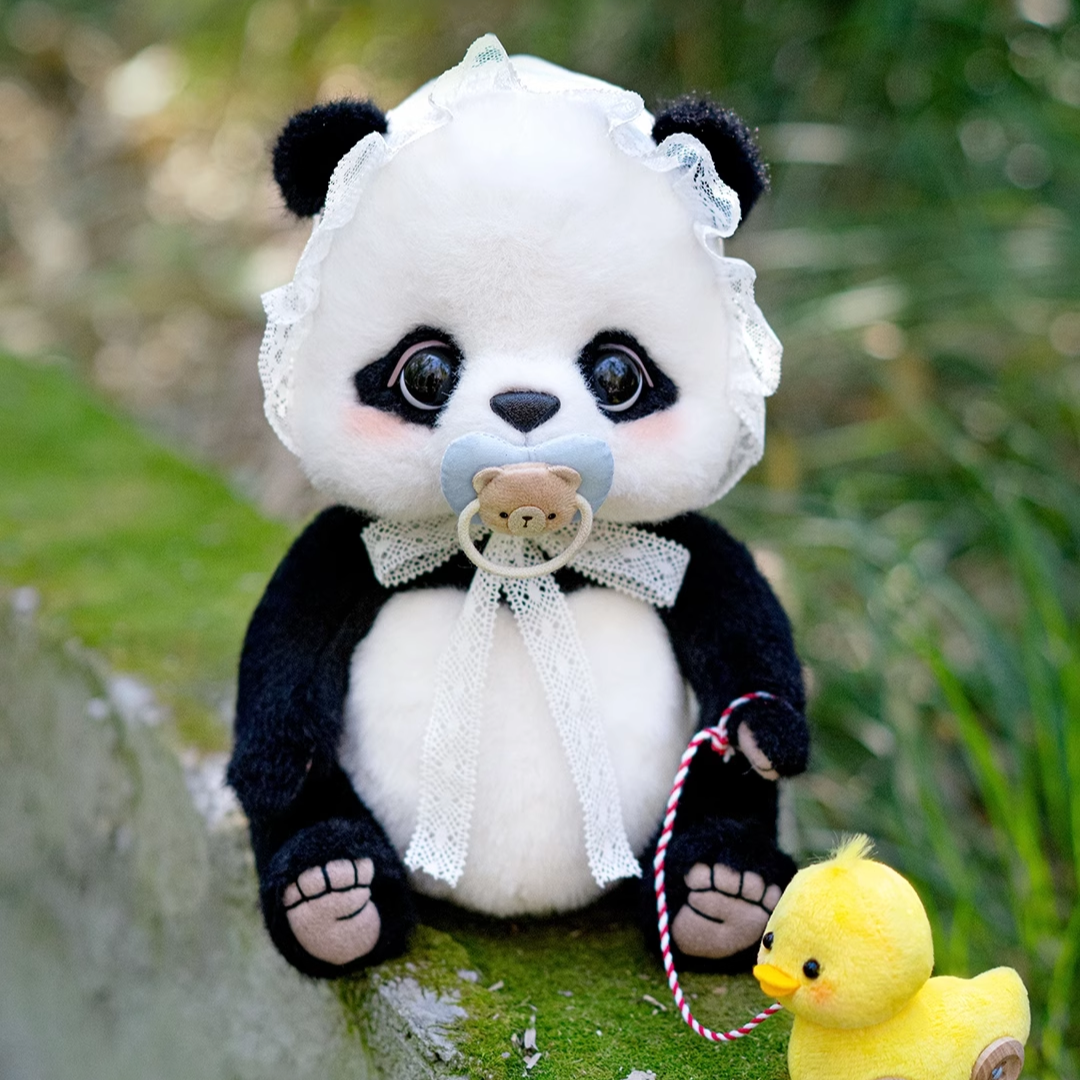 Stuffed panda toy with a pacifier and a yellow rubber duck on a natural background