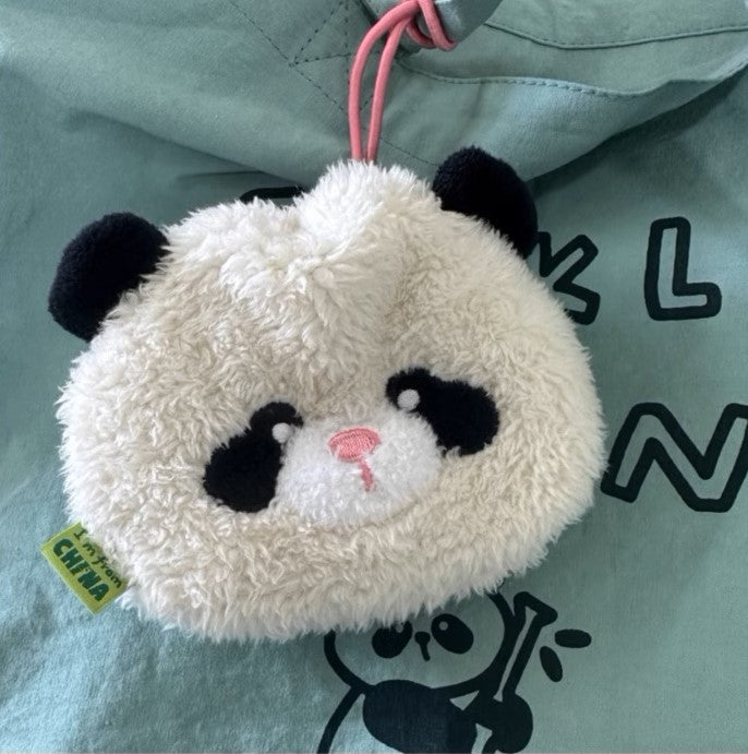 Plush panda keychain on a light blue background with black text