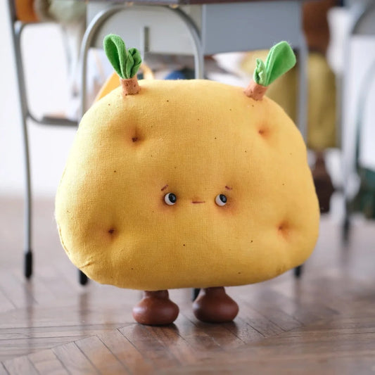 Yellow plush toy with a face on a wooden floor