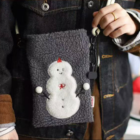 Person wearing a dark jacket with a gray fleece pocket featuring a snowman design.