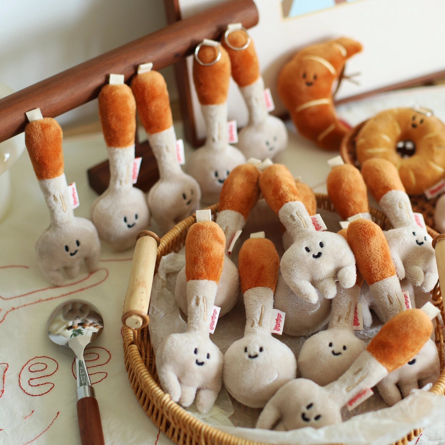 Plush toys spoon and fork in a basket on a table.