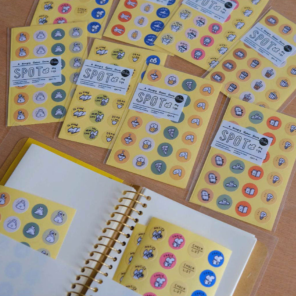 Sticker sheets with colorful stickers on a wooden surface