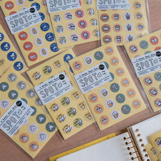 Set of yellow sticker books with various stickers on a wooden surface
