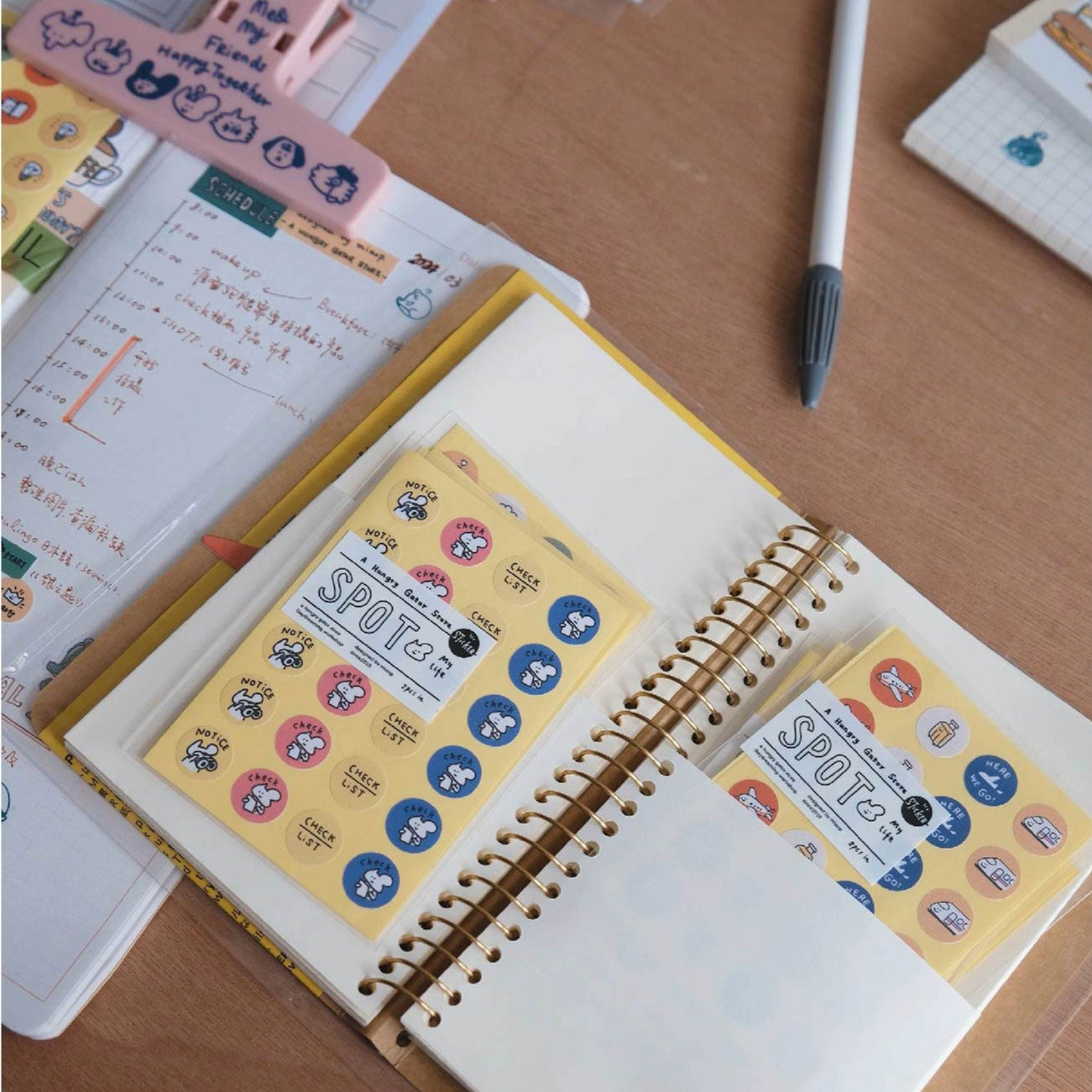 Open notebook with colorful stickers on a wooden surface