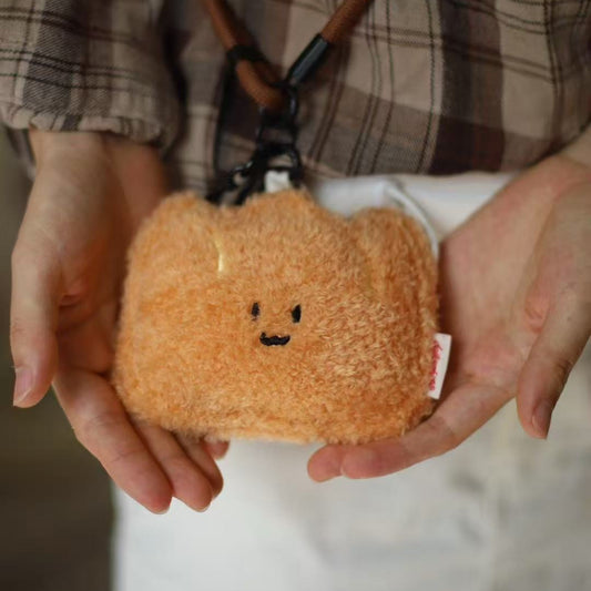 Person holding a plush bread toy with a face design.