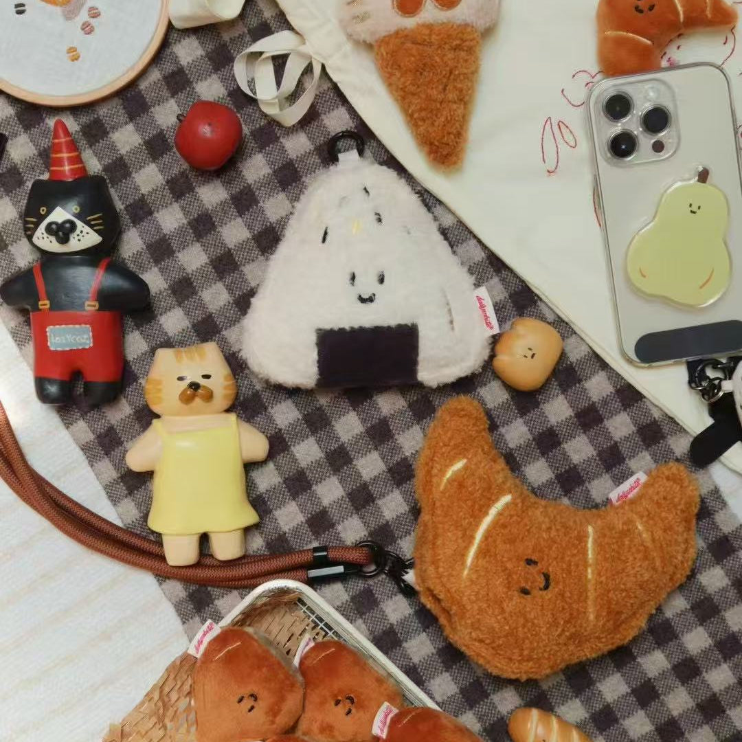 Various cute plush toys and phone cases on a checkered fabric background