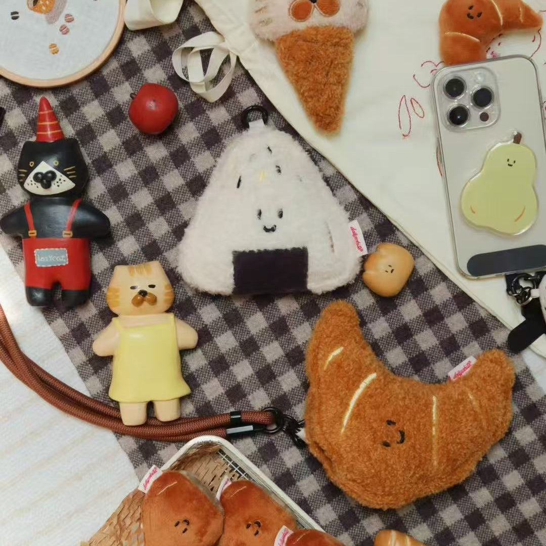 Various cute plush toys and phone cases on a checkered fabric background