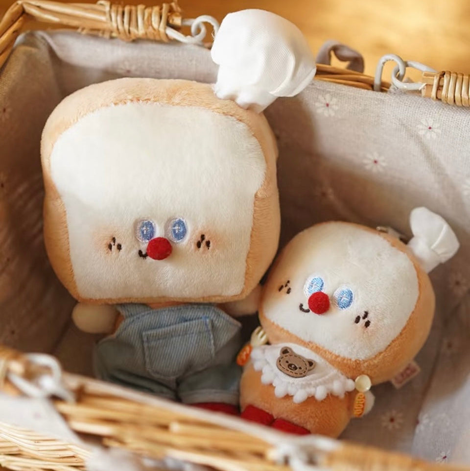 Two plush toys resembling slices of bread with faces in a wicker basket.