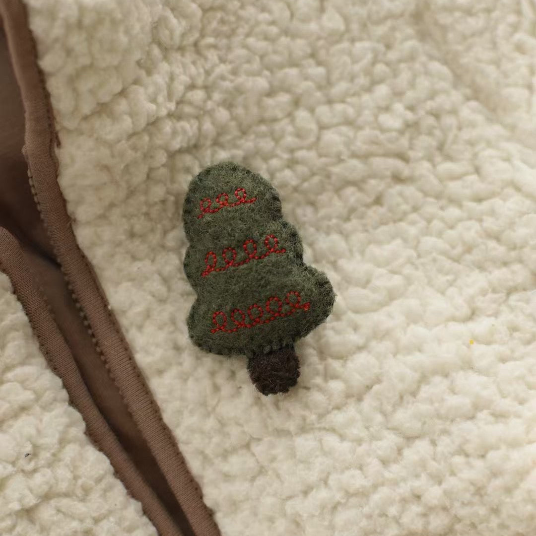 Green embroidered patch with text on a beige sherpa fabric background