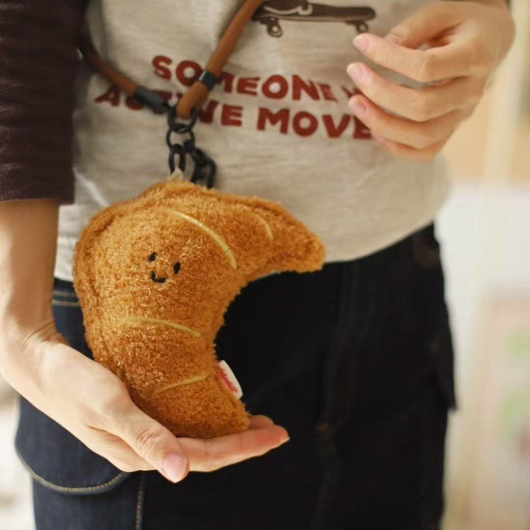 Person holding a plush crescent moon toy with a blurred background