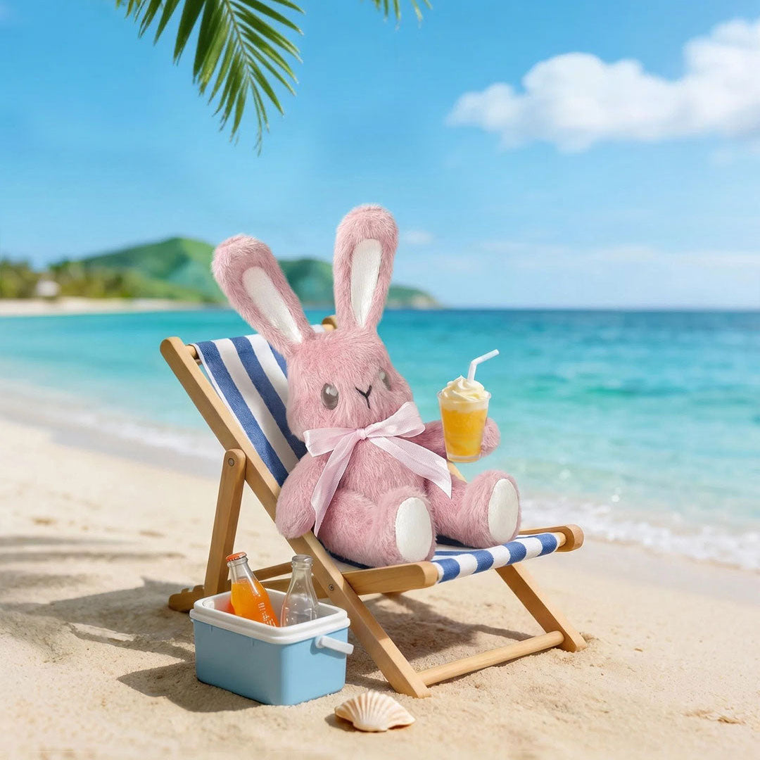 Pink plush bunny sitting on a striped beach chair with a drink, surrounded by palm leaves and ocean view.