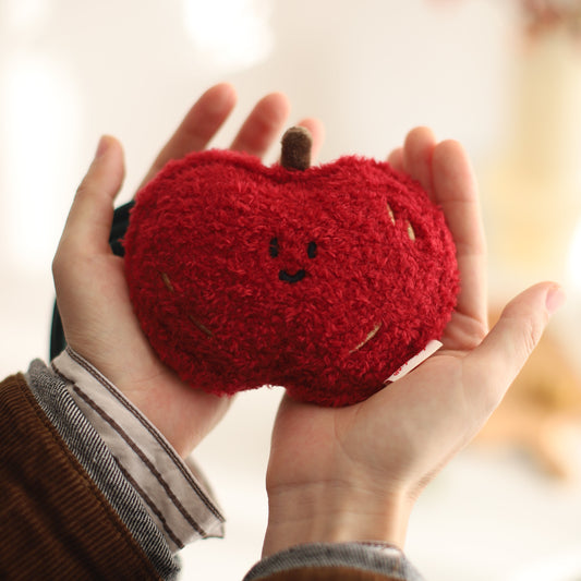 Red apple held in hands with a blurred background