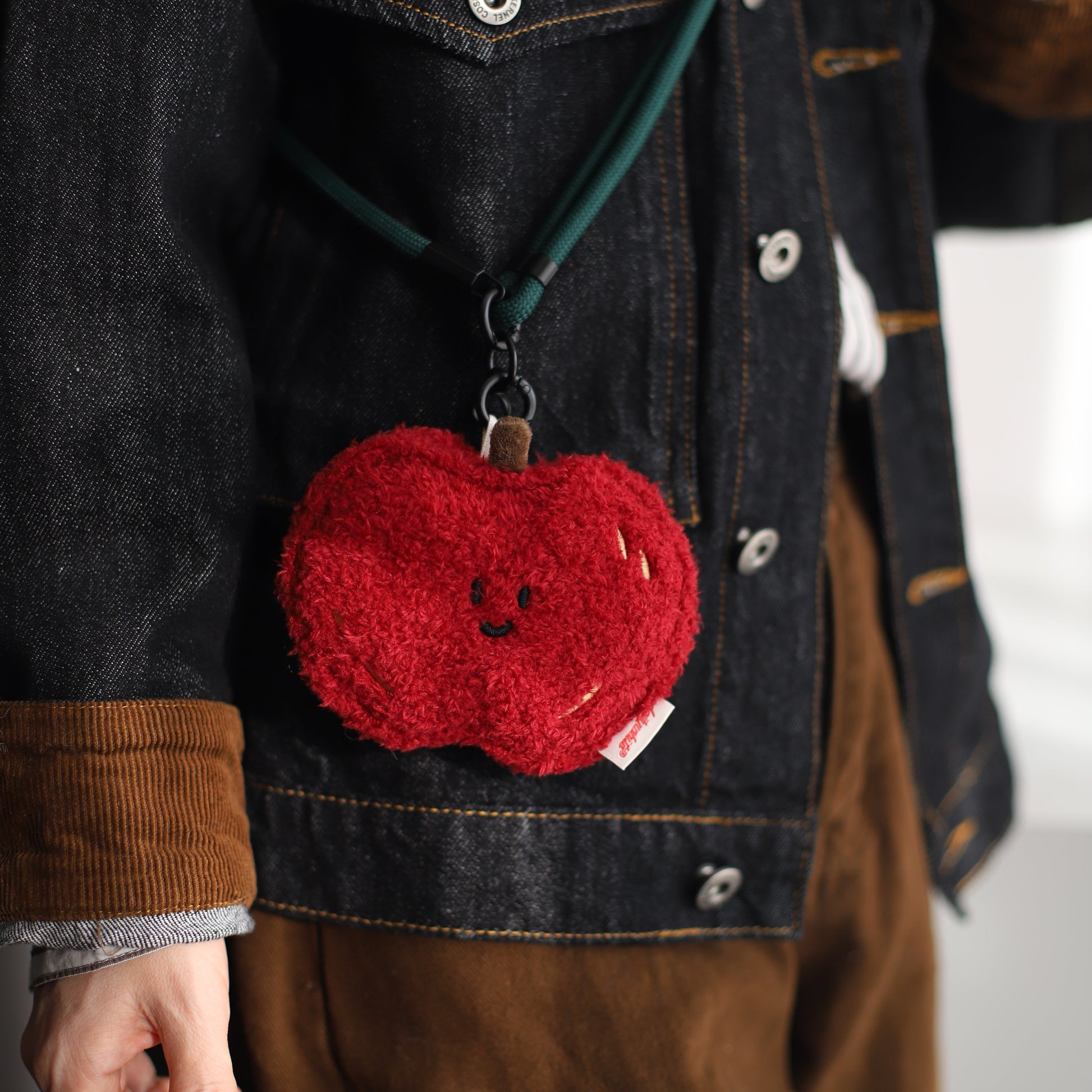 Red apple bag on a dark denim jacket