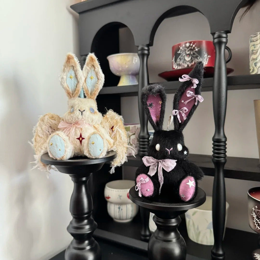 Decorative bunny figurines on black stands with a shelf in the background.