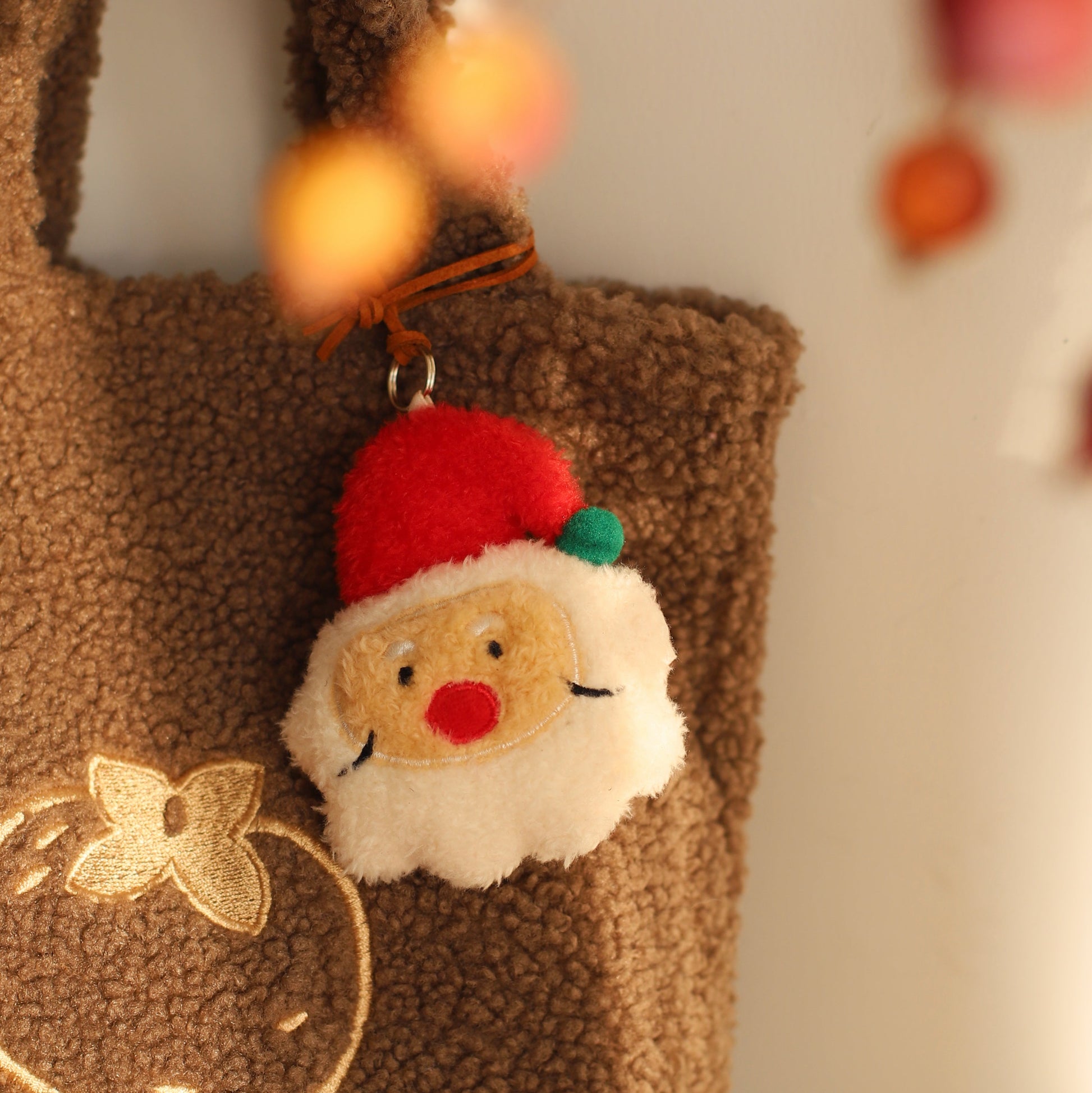 Brown textured bag with a Santa Claus keychain on a blurred background