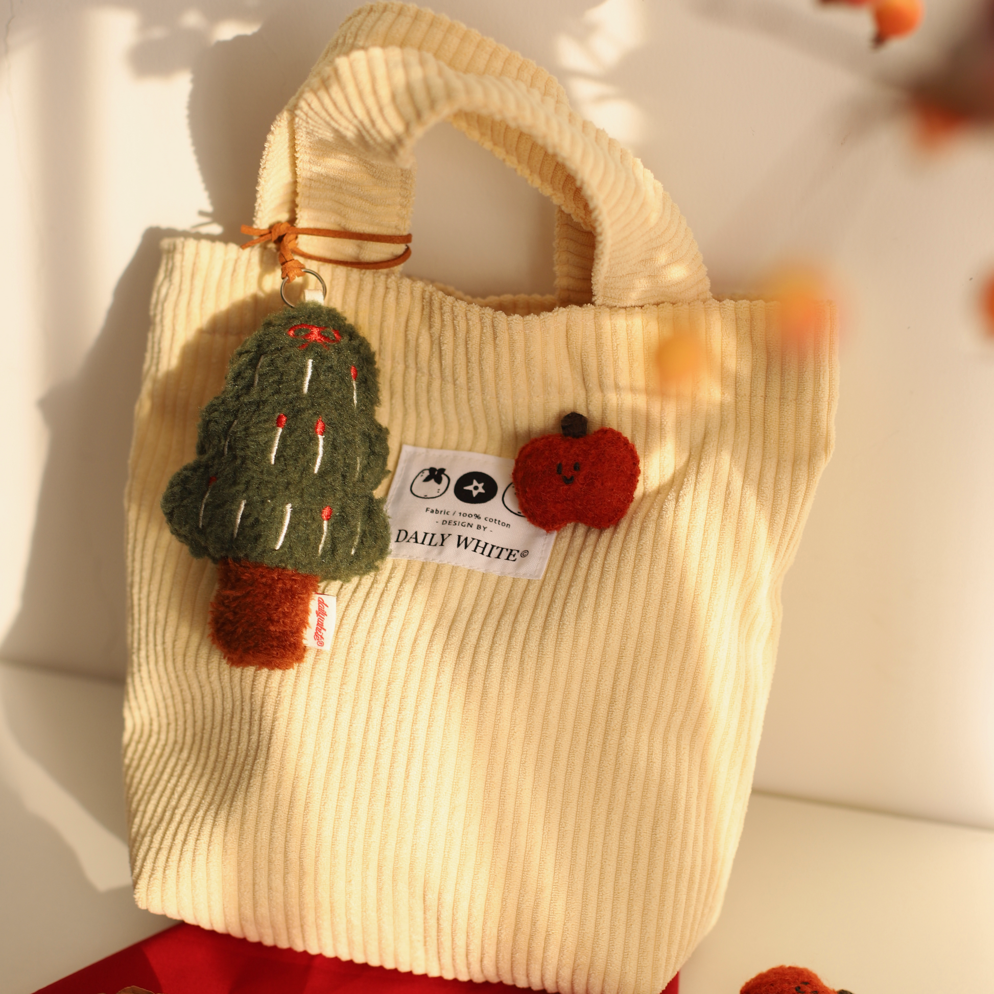 Beige textured bag with Christmas tree and reindeer decorations on a white background