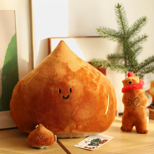 Plush chestnut-shaped toy on a wooden surface with a small bear plush toy and decorative cards.