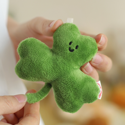 Green plush clover held by a hand against a blurred background