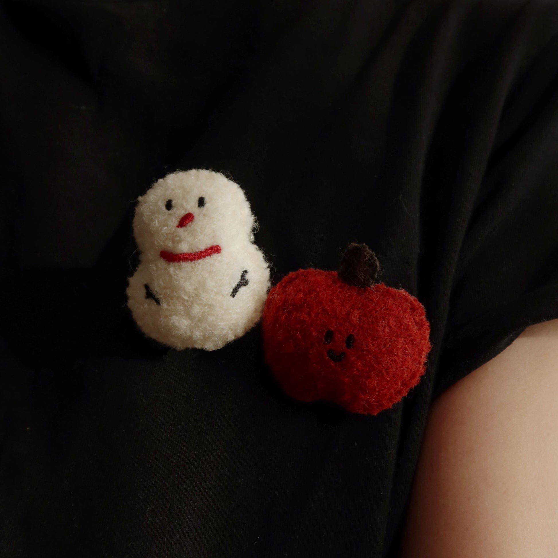 Black t-shirt with a snowman and pumpkin design on a plain background