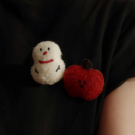 Black t-shirt with a snowman and pumpkin design on a plain background