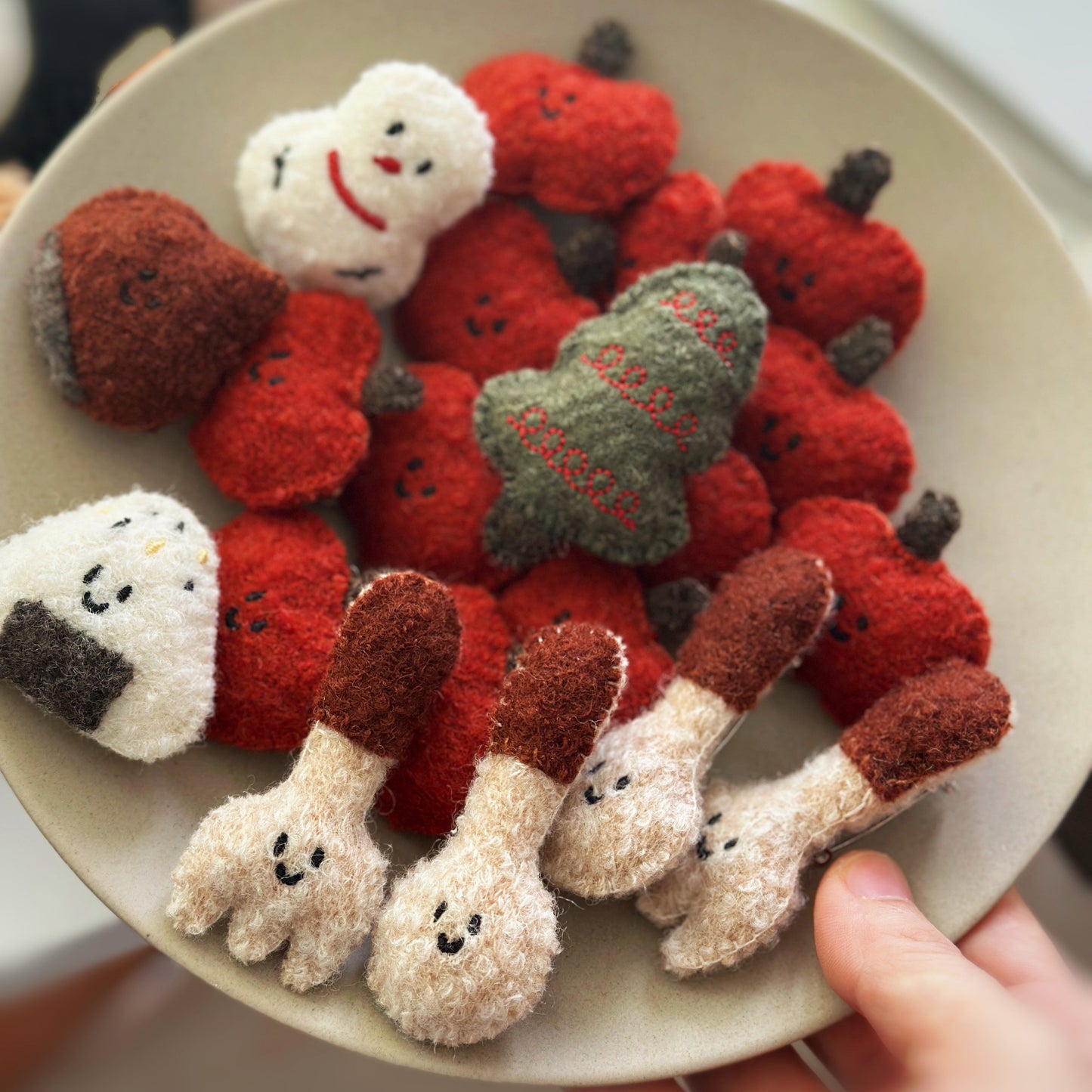 Plate with red and white strawberry-shaped figurines on a neutral background