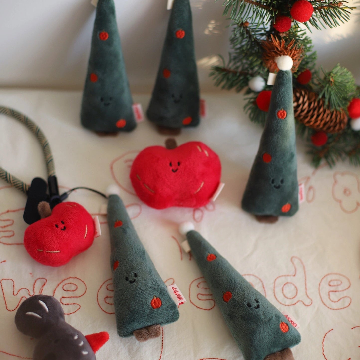 Set of Christmas-themed felt decorations including trees and a reindeer on a white surface with 'we love' text.