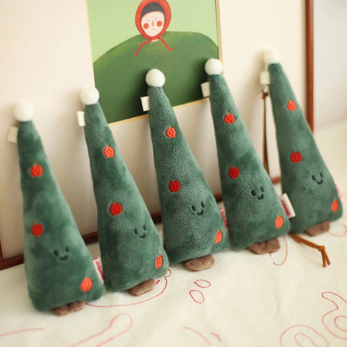 Set of green plush trees with red dots on a white surface