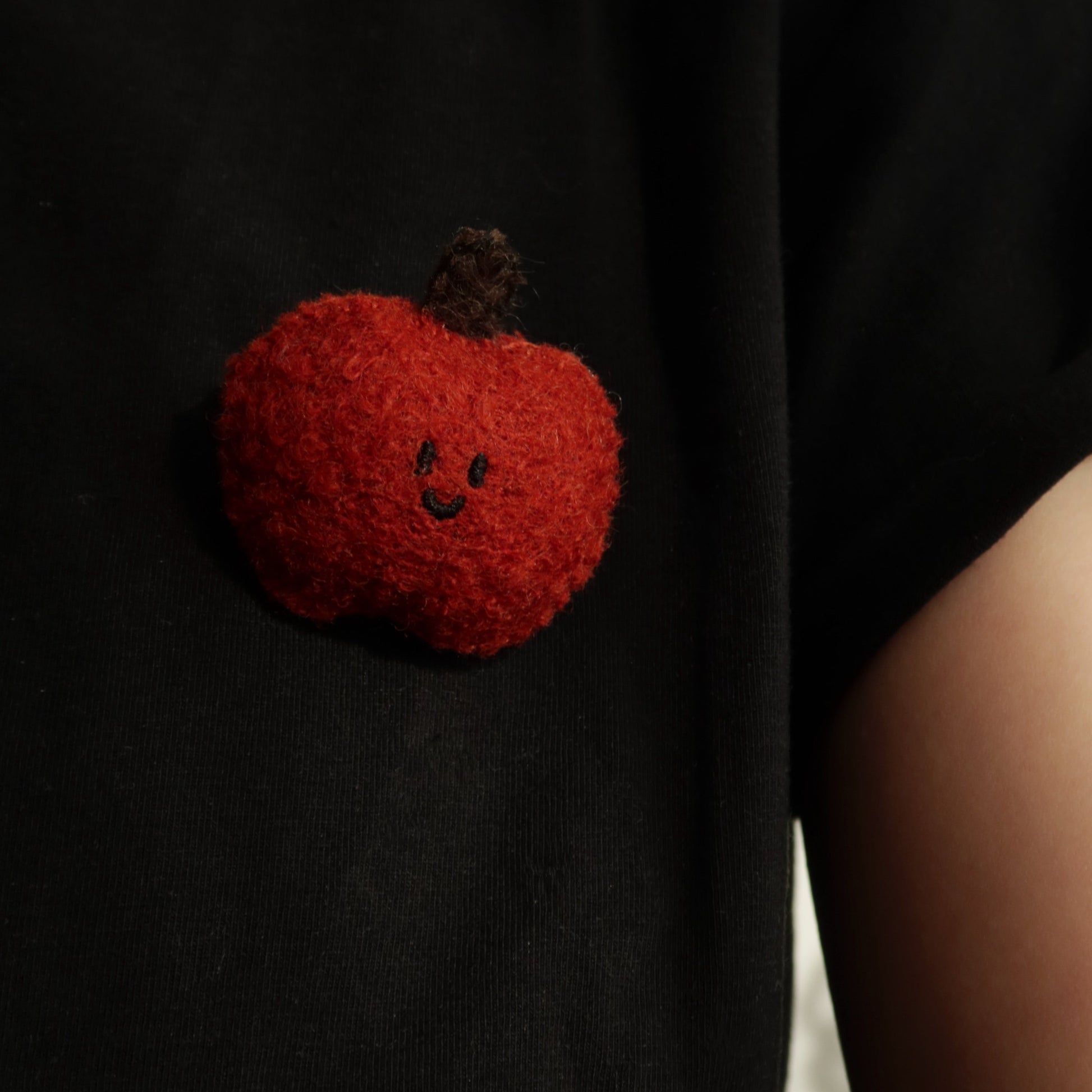 Black t-shirt with a red pumpkin patch on a plain background