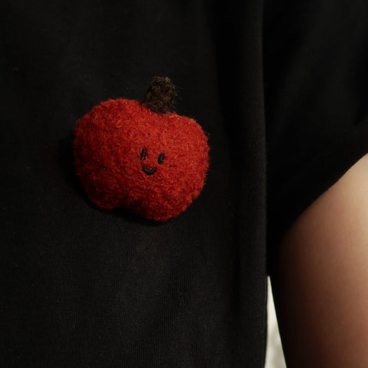 Black t-shirt with a red pumpkin patch on a plain background